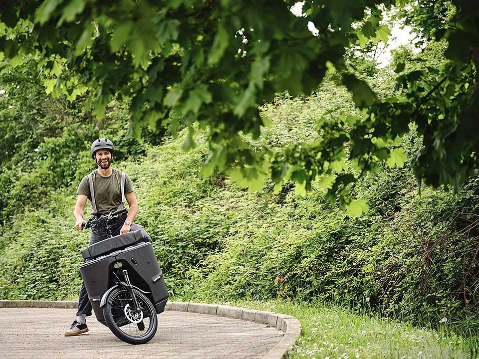 Ein JobRadler auf dem Lastenrad steht in einer Kurve